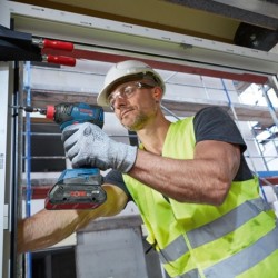 Operario atornillado ventana con la herramienta Bosch GDX 18V-200